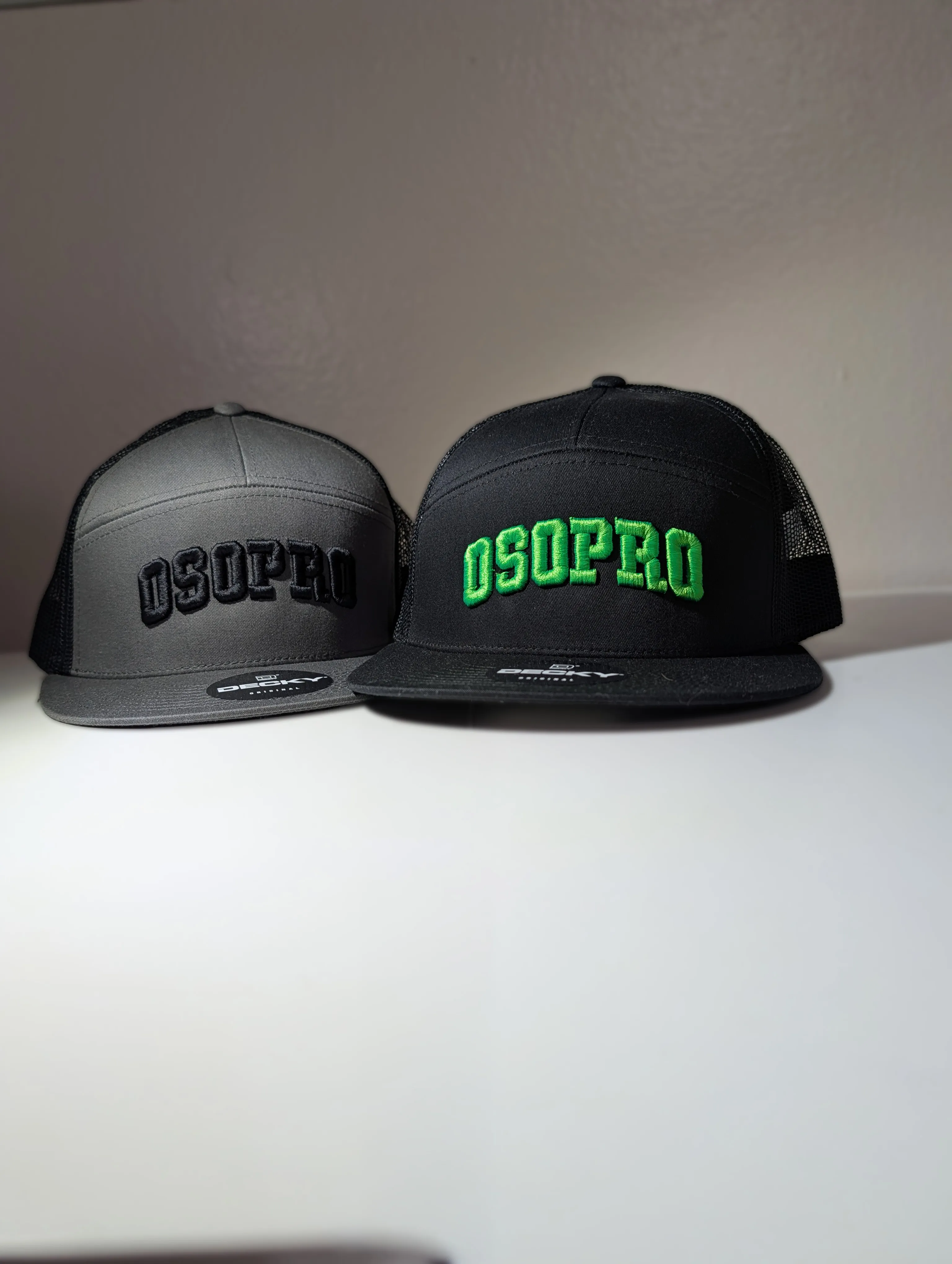 Two custom trucker caps with embroidered 3D puff logo stitching